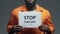 Stop tortures phrase on cardboard in hands of Afro-American prisoner, assault