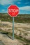 STOP traffic signpost and rocky landscape