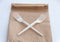 Stop using plastic. Plastic waste concept. Close up. Brown ecological paper bag and crossed plastic forks on it. Concept of