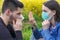 Stop the viral infection, Girl with protective mask and sneezing boy in the floral park