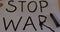 Stop war handmade poster in support of peace. Writes black words on white paper.