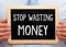 Stop wasting Money - Manager with chalkboard
