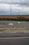 Stopping place with street lamps next to an abandoned warehouse on a cloudy day in the italian countryside