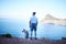 Stopping to take in the view. Rearview shot of an unrecognizable young man and his pet husky taking in the views during