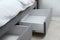 Storage drawers for bedding under modern bed in room, closeup