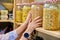 Storage of food in the kitchen in pantry, woman's hands with can of dry peas