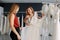 Store assistant helps the bride in choosing perfect attire