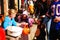 A store employee hands out treats to costumed trick or treaters in a downtown district