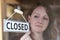 Store Owner Turning Closed Sign In Shop Doorway