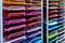 In the store, there are sheets of multi-colored paper on the racks. large selection of colors