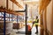 Storehouse employee in uniform working on forklift in modern automatic warehouse. Boxes are on the shelves of the warehouse.