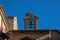 Stork\\\'s nest perched and built with branches above the bell tower and a small bell of the old cathedral of Salamanca
