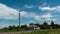 Stork sits on a pole in the village and moving clouds. Time lapse