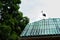 Stork sits on the roof of the house, against the background of the blue sky