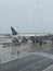 Storm at the airport before onboarding. View of the airplane through rain drops. Themes weather, delay .canceled flight.