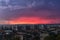 A storm is approaching the city in the late evening. Gleams of distant lightning reddened the sky above the hills outside the city