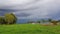 storm arriving at a farm with three horses in the interior of Brazil