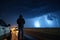 storm chaser in extreme weather conditions, with lightning and rain visible