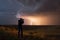 storm chaser filming lightning strike on stormy night