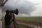 storm chaser filming tornado with high-speed camera for scientific research