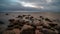 storm clouds forming over clear sea beach with rocks and clear s