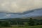 Storm clouds gather over lush farmland in the Highlands of Scotland