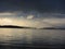 Storm clouds and rain falling on the horizon, lake landscape