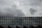 Storm clouds reflect in windows of office building/ Mirror windows with overcast sky reflections/ corporate building facade