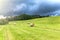 Storm clouds in a summer day in the field. Hay harvest on the farm. Hay bales and dramatic sky. Waiting for the rain