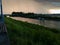 Storm cumulonimbus cloud with heavy rain or summer shower, severe weather and sun glow behind rain. Landscape with Sava river with