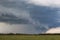 Storm cyclone over summer fields, hills and forests