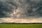 Storm cyclone over summer fields, hills and forests