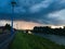 Storm dark cloud with heavy rain or summer shower, severe weather and sun glow behind rain. Landscape with Sava river and