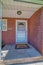 Storm door and gray front door at home facade with red brick stone wall
