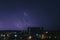 Storm over city. Lightning shines in the sky over the night city.