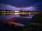 Storm overcast with thunderclouds and the glow of lightning. Landscape with city of Slavonski Brod in Croatia, calm river Sava and