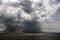 Before the storm. A painted view of storm and rain clouds and the sky above the sea horizon.