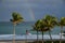 The storm passes by the sandy beachfront and leaves a beautiful rainbow behind