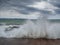 Storm on the resort coast. Storm waves are breaking on the pier. Dramatic cloudy sky and strong wind