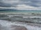 Storm on the resort coast. Storm waves are breaking on the pier. Dramatic cloudy sky and strong wind