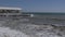 Storm at sea. Large waves crash against the concrete breakwater. Empty summer restaurant by the sea.