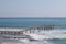 Storm on the sea, waves of foam against the background of the beach pier, Alanya, December 2023.