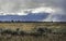 Storm showers cross the landscape in the Teton mountains.