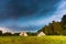 Storm sky over meadow, house and forest