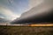 A storm at sunset with large shelf cloud on the great plains.