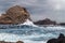 Storm waves at the ocean shore against the background of a high solitary rock