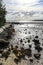 Stormwater drain leading to sun setting over ocean at low tide