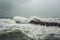 Stormy Baltic sea with big waves and wooden pier. Generative AI