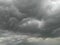 Stormy black clouds in sky over city, wind blowing trees, nature photography, rainy season weather conditions, atmospheric moods