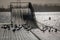 stormy clouds over a pier with black birds and dark lake